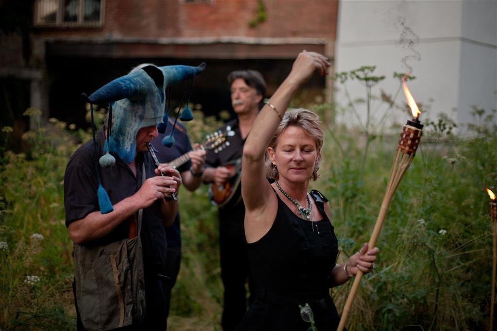 Performers with a torch and instruments at the tunnel entrance. Photograph by Alex Green.